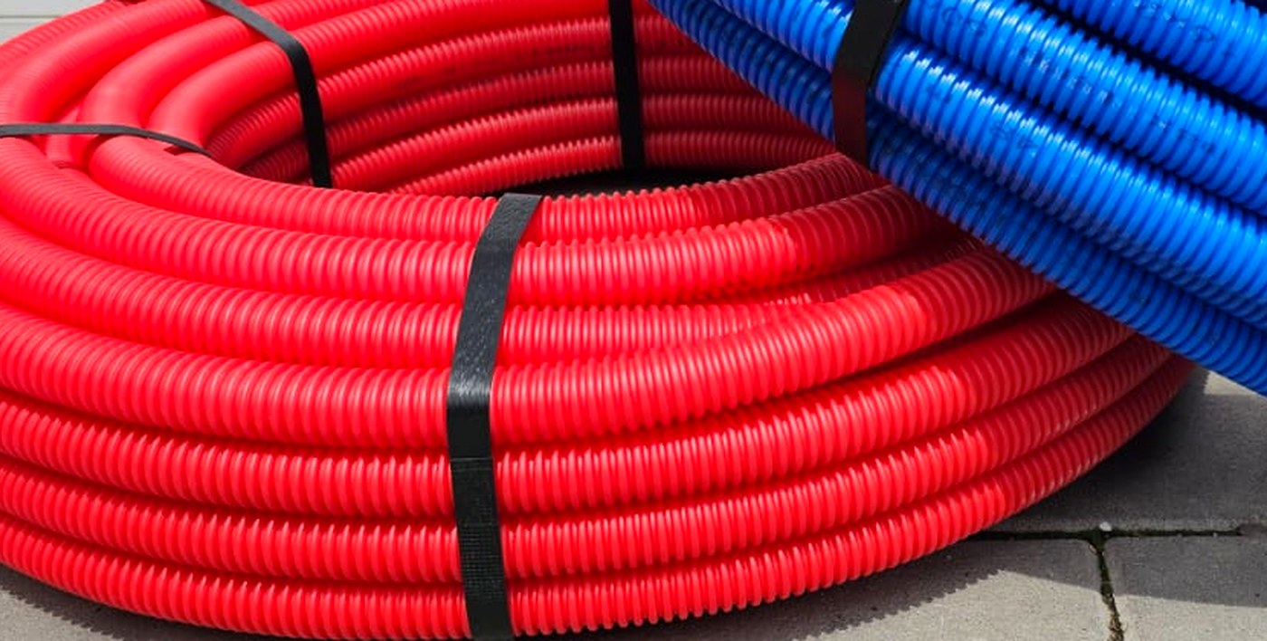 Coils of blue and red Livoplast pipe stacked together.
